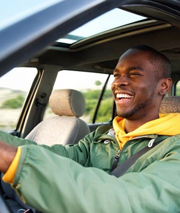 Man smiles while driving