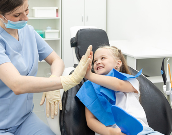 Young girl high-fiving dental hygienist